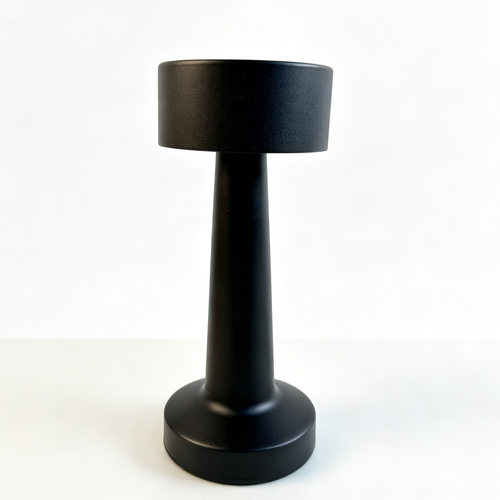 Rechargeable black table lamp with slim metal body and weighted round base on wooden surface providing warm downward light