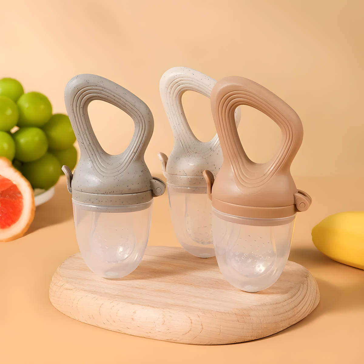 Silicone baby food feeder with textured loop handle and clear food chamber for soft fruit feeding