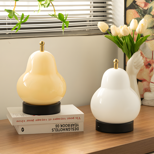 Glass Pear Table Lamp with black base and brass detail illuminating a cozy room corner