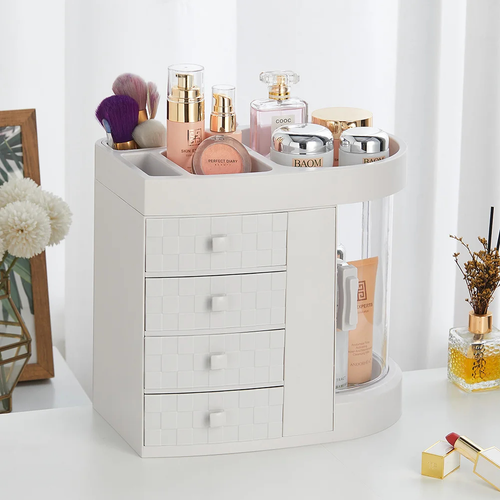 White rotating makeup organizer with clear drawers and compartments for cosmetics and brushes on a vanity table