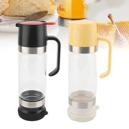 Clear honey dispenser with handle and no-drip spout on white background